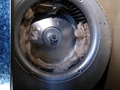 blower wheel from a furnace filled with plastic debris