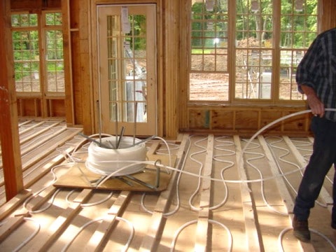 Radiant in-floor heat being installed during new construction. radiant pex tubing being installed below subfloor