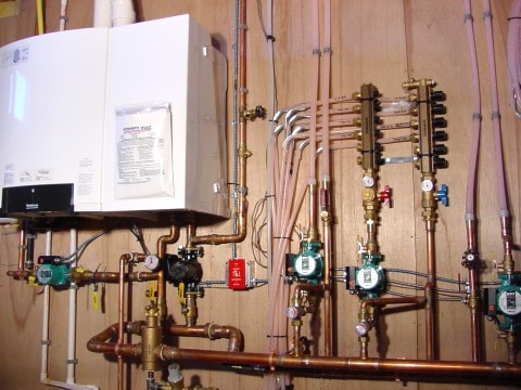 Boiler, controls, valves all wall-mounted in basement. wall-mounted boiler and radiant heating system