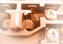 Closeup view of a stuck compressor contactor, which should be replaced right away. Pitted contactor, stuck contactor