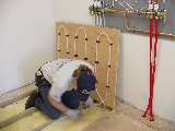 Installing insulation in floor joist bays